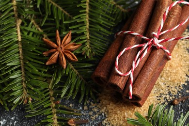 Photo of Different aromatic spices and fir branches on grey table, above view