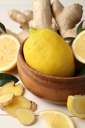 Photo of Fresh lemons and ginger on white wooden table, closeup