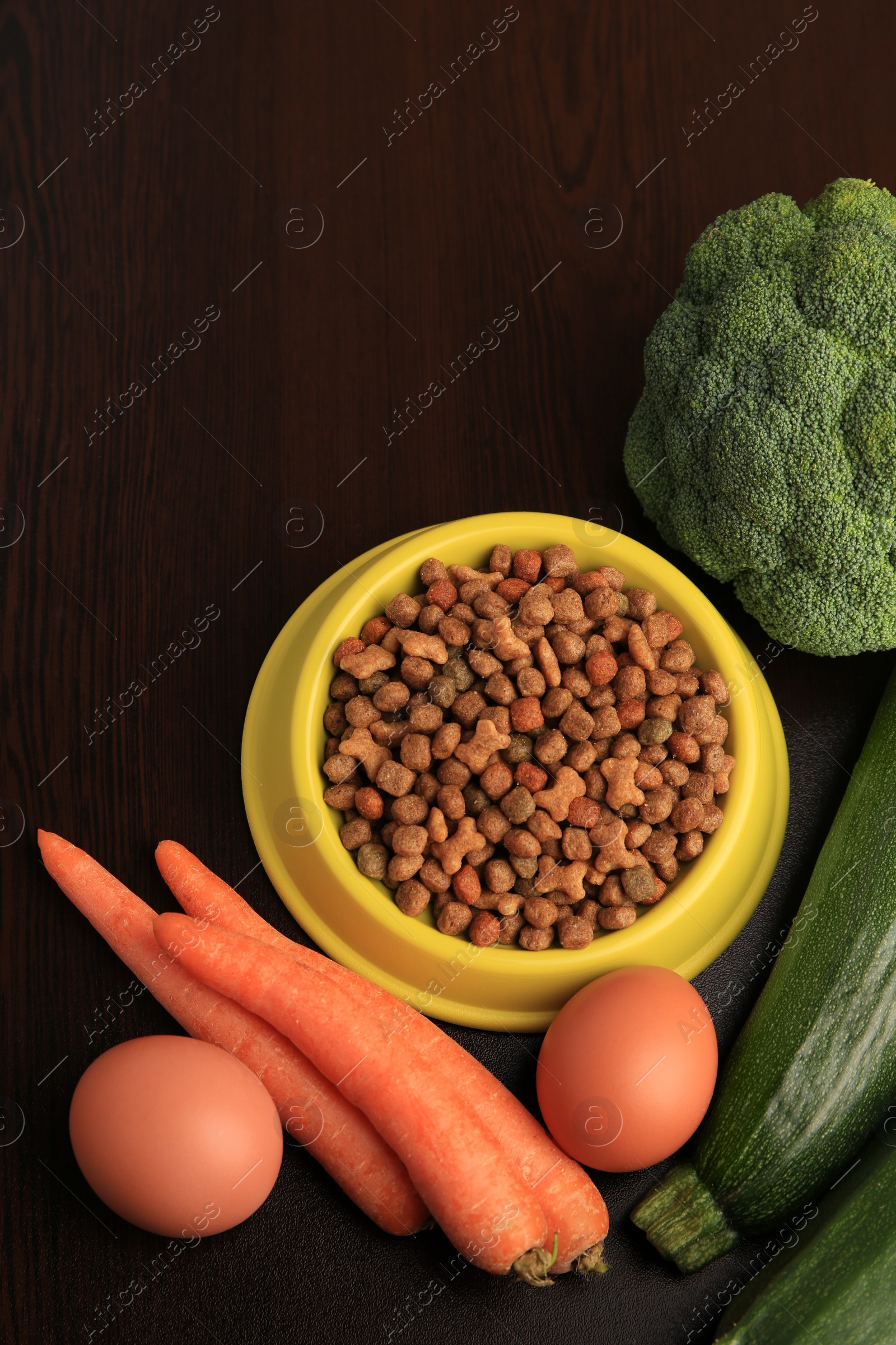 Photo of Dry pet food and products on wooden background, flat lay. Space for text