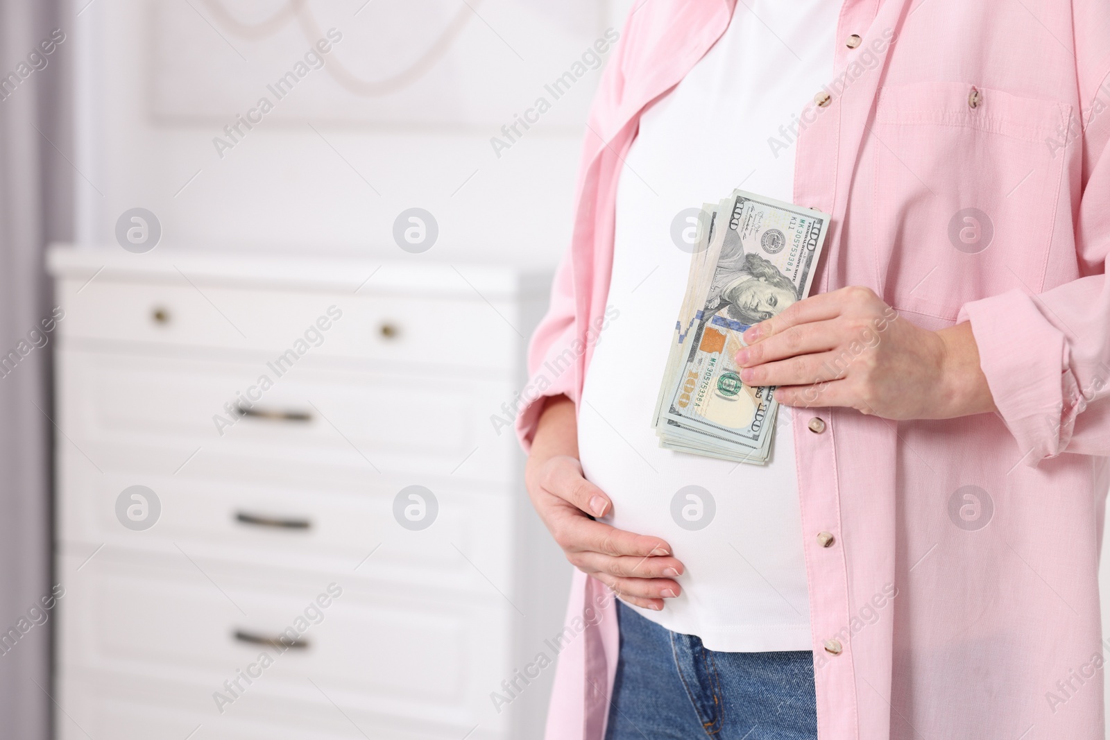 Photo of Surrogate mother. Pregnant woman with dollar banknotes indoors, closeup. Space for text