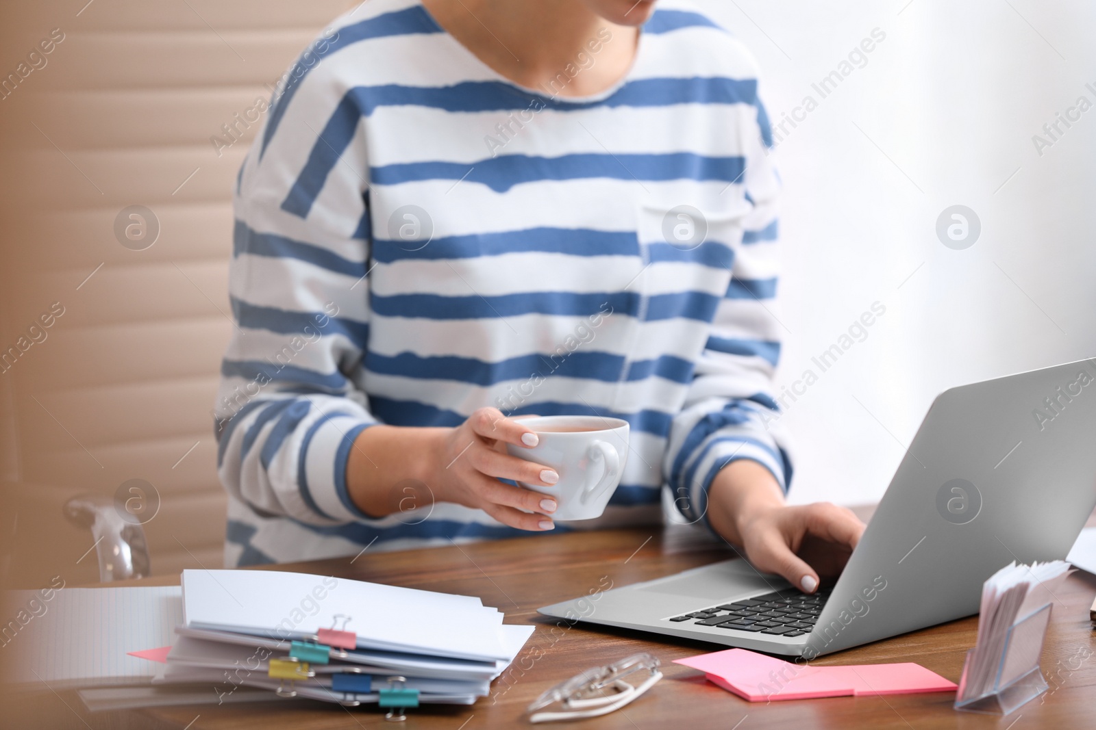 Photo of Young journalist working with laptop in office, closeup