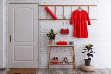 Hallway interior with stylish furniture, shoes and plants