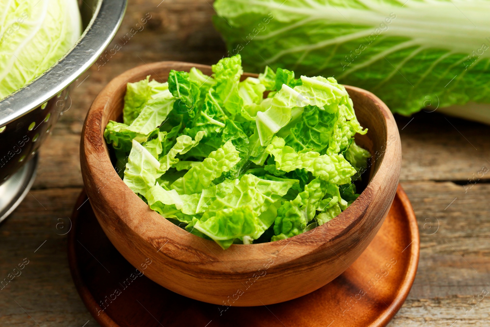 Photo of Cut fresh Chinese cabbage on wooden table, closeup