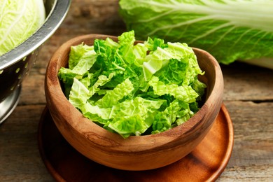 Photo of Cut fresh Chinese cabbage on wooden table, closeup