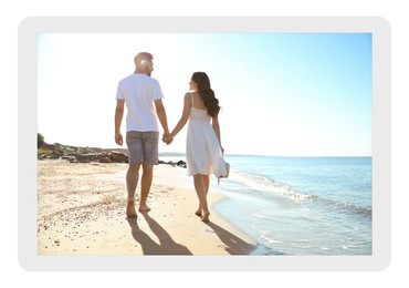 Paper photo. Happy young couple walking on beach near sea 