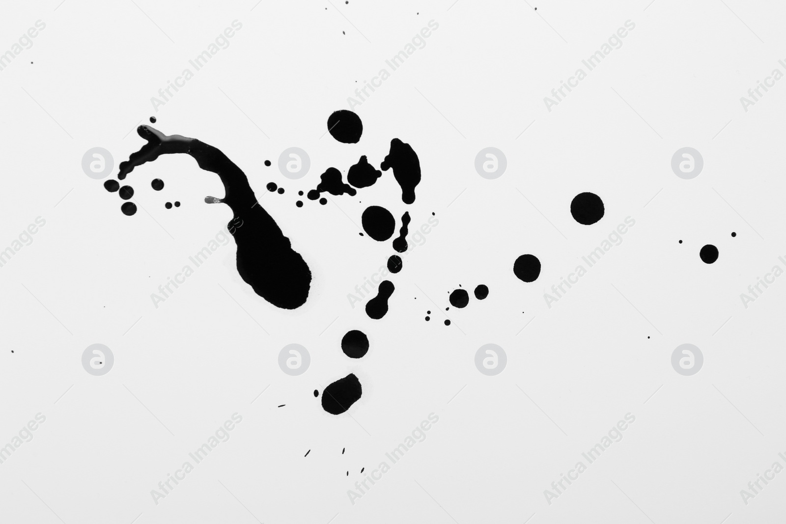 Photo of Blots of black ink on white background, top view