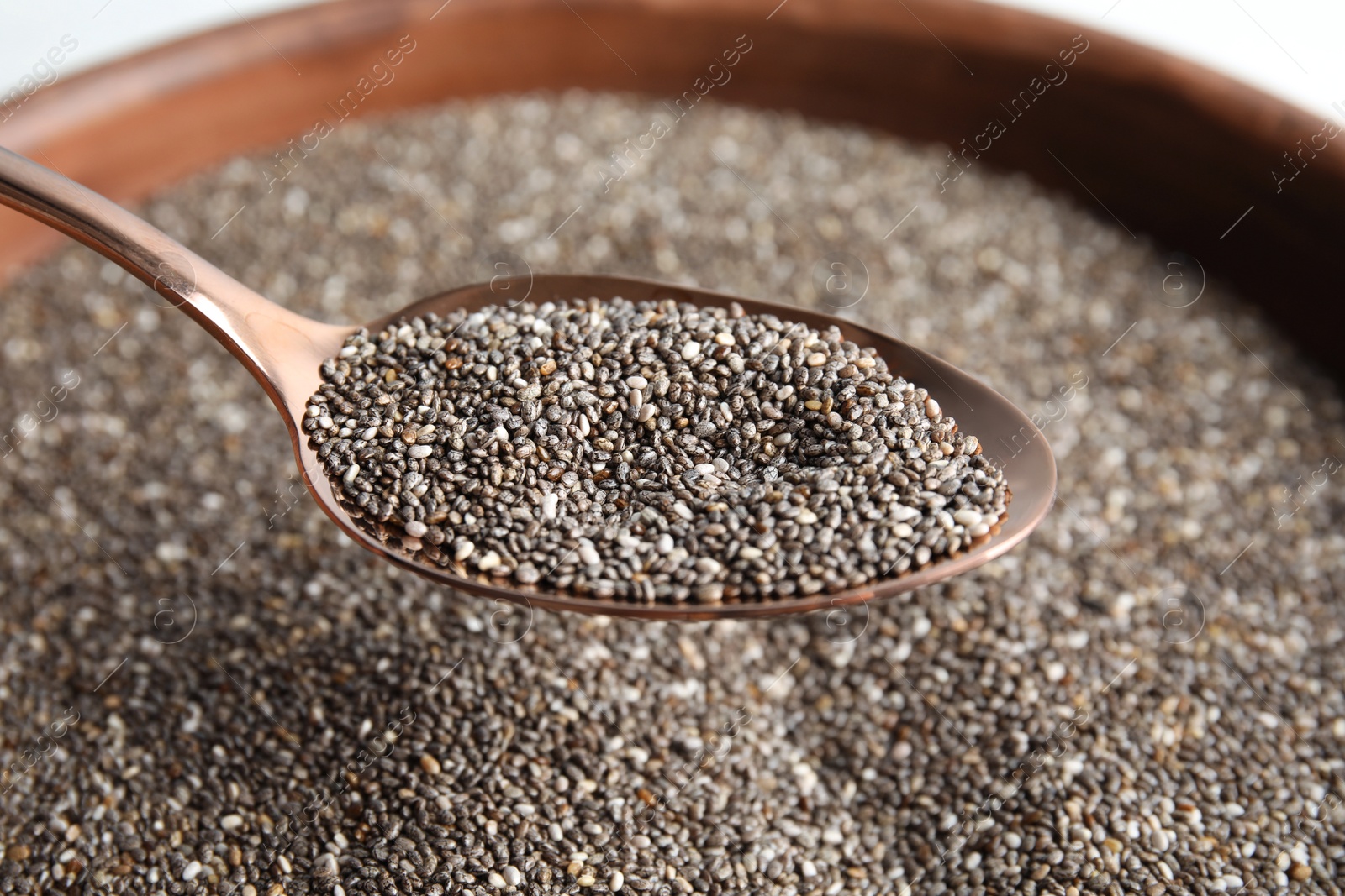 Photo of Closeup of spoon with chia seeds over bowl