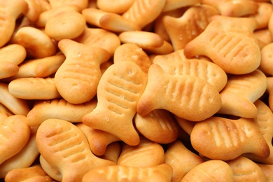 Delicious goldfish crackers as background, closeup view