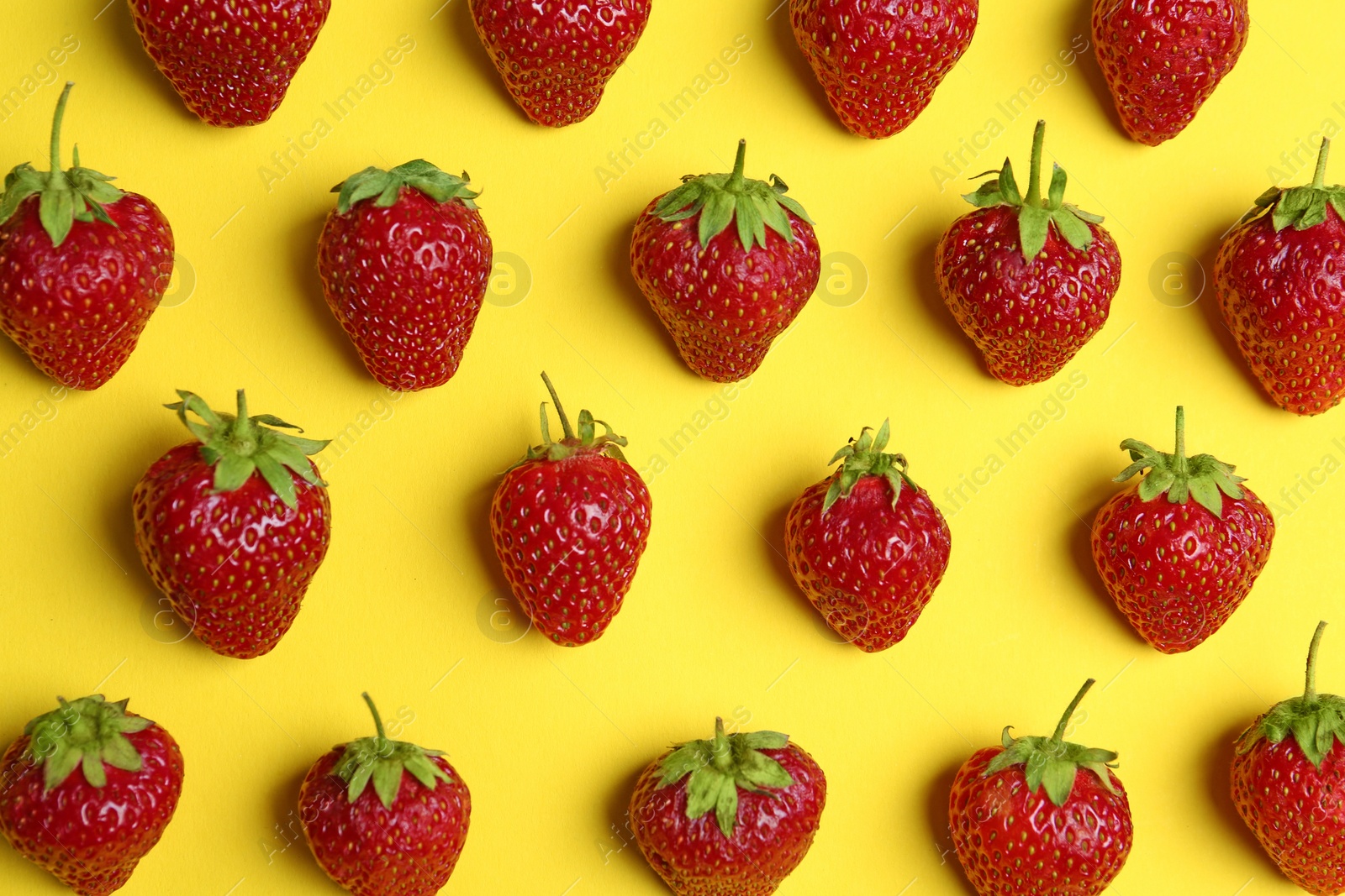 Photo of Tasty ripe strawberries on yellow background, flat lay