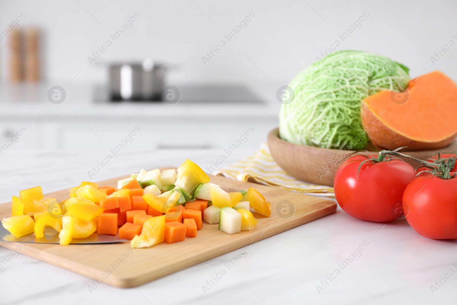 Photo of Different raw vegetables on white marble table in kitchen