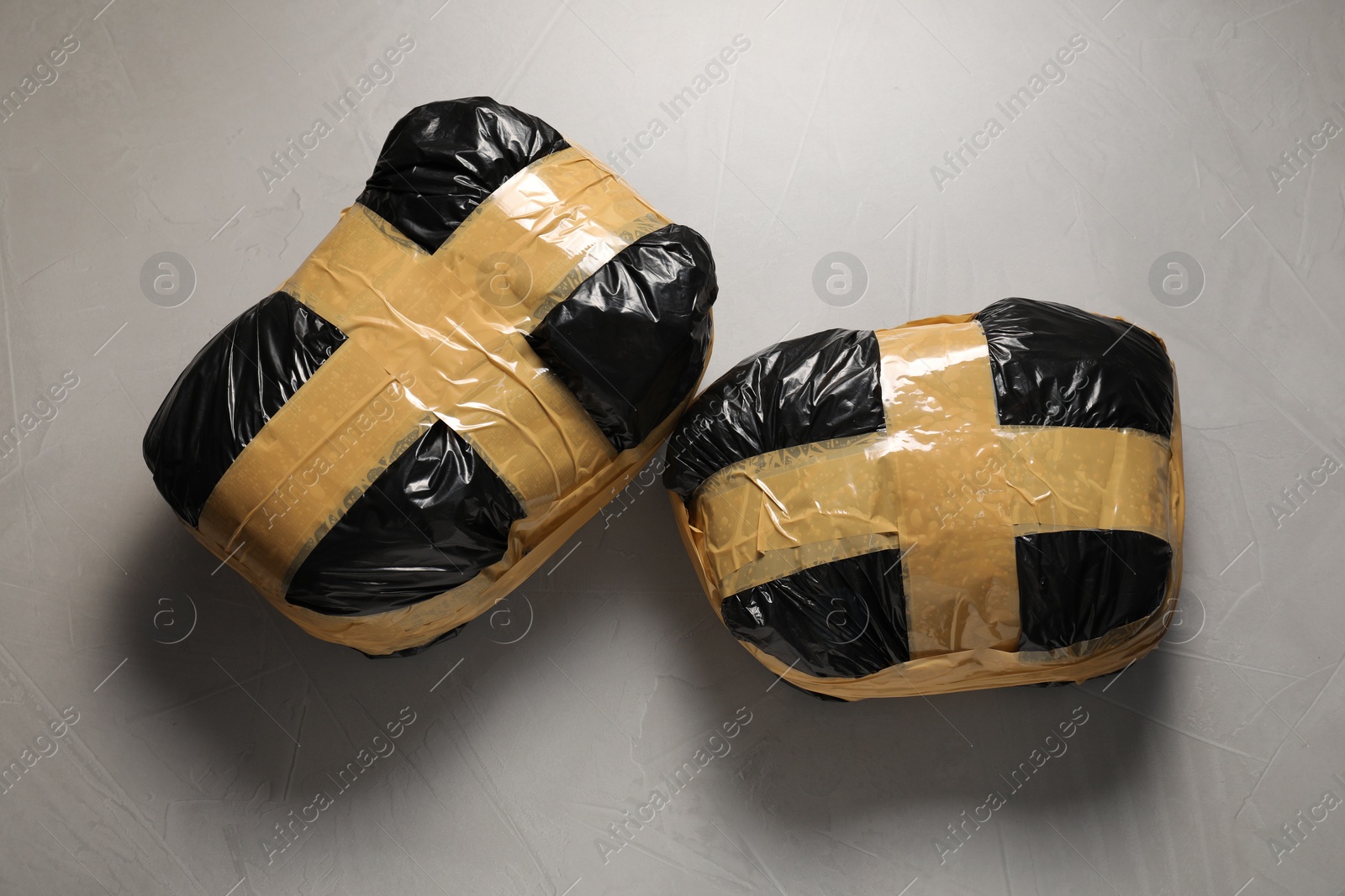 Photo of Packages with narcotics on grey textured table, top view