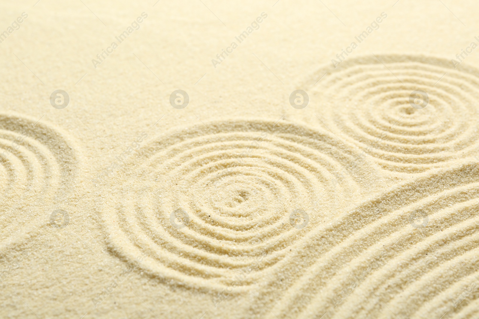 Photo of Zen rock garden. Circle patterns on beige sand