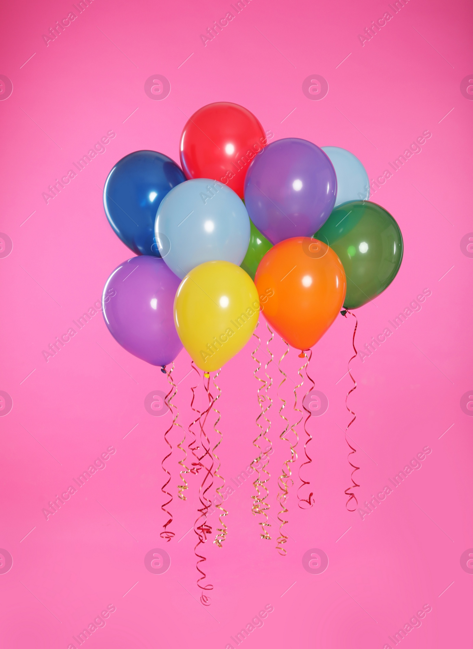 Photo of Many bright balloons floating on color background