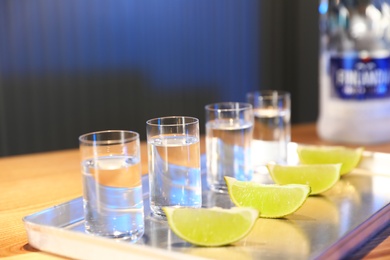 Photo of MYKOLAIV, UKRAINE - SEPTEMBER 23, 2019: Finlandia vodka and lime slices on bar counter