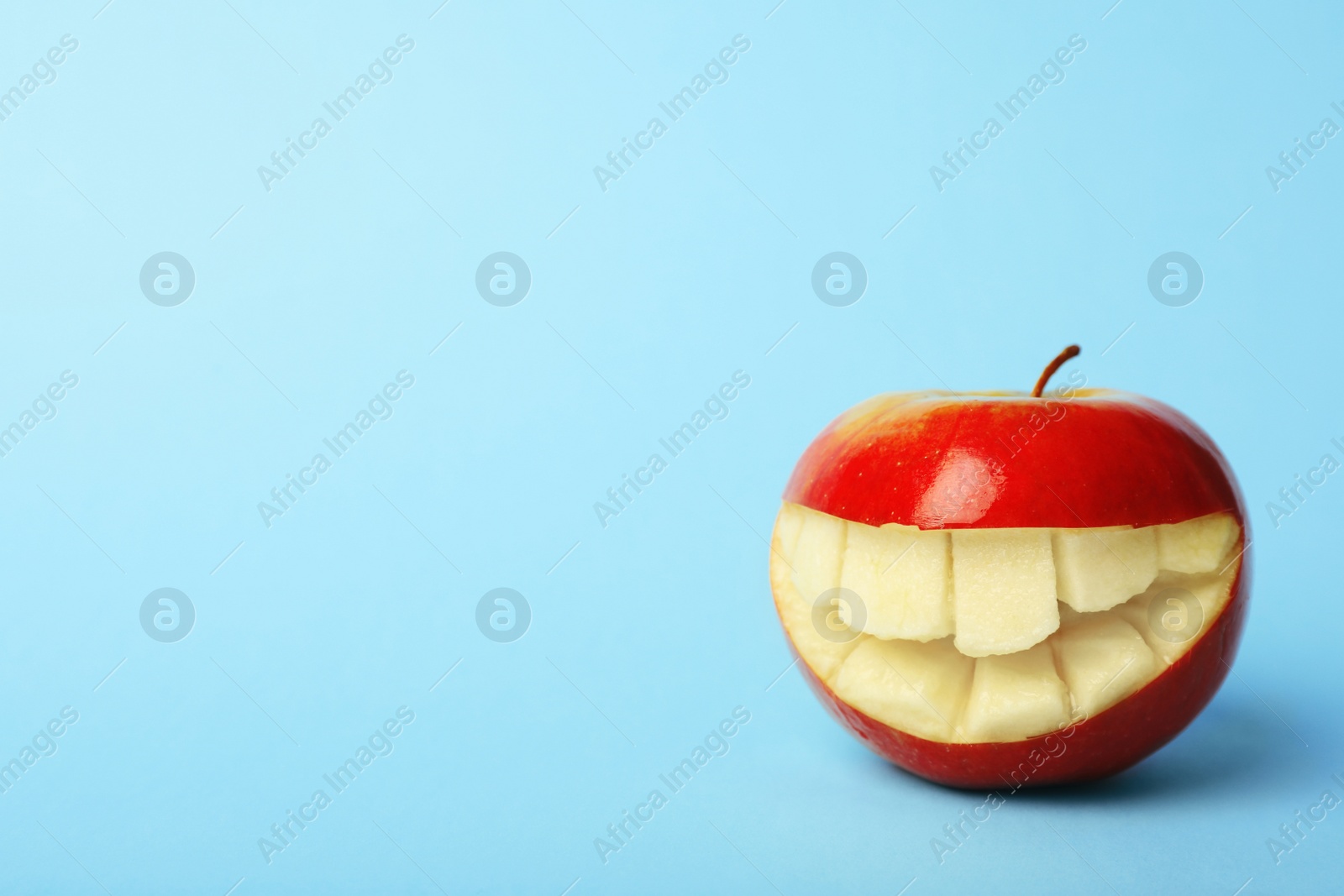 Photo of Funny smiling apple on color background. Space for text