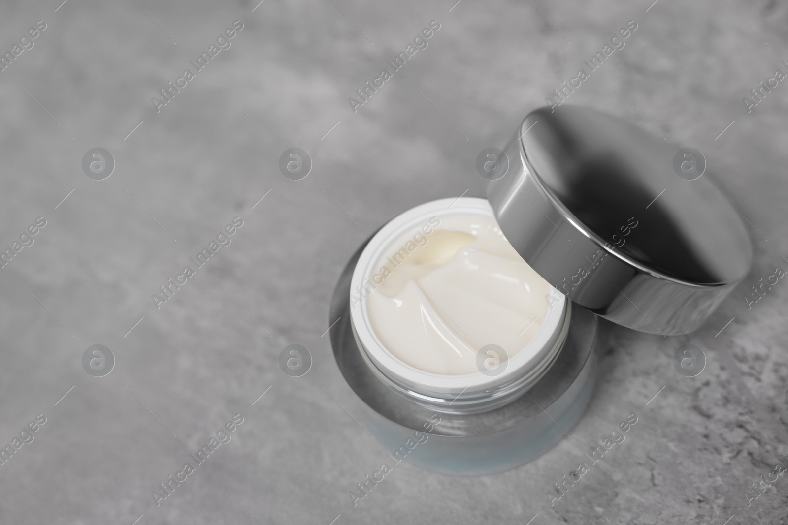 Photo of Body cream on grey table, space for text