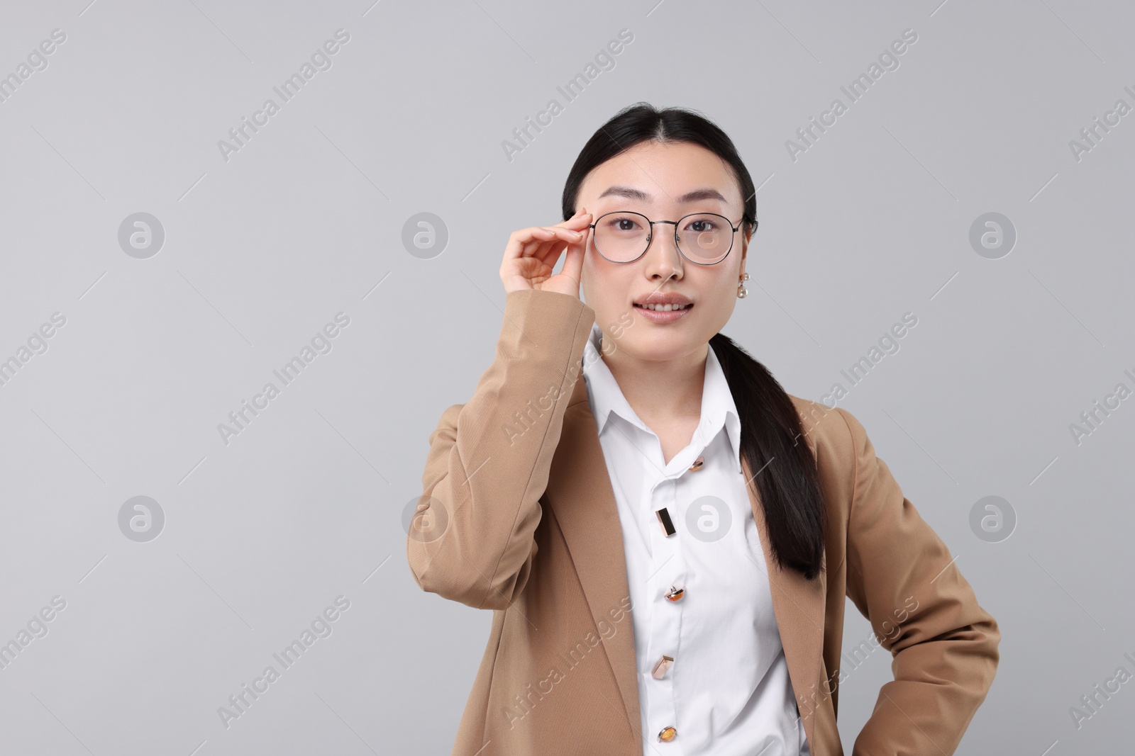 Photo of Portrait of beautiful businesswoman on grey background. Space for text