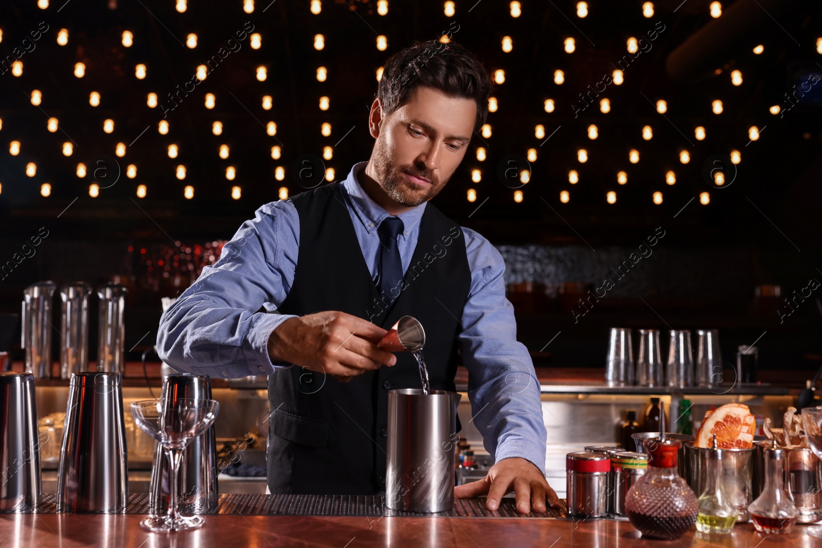 Photo of Bartender preparing fresh alcoholic cocktail in bar