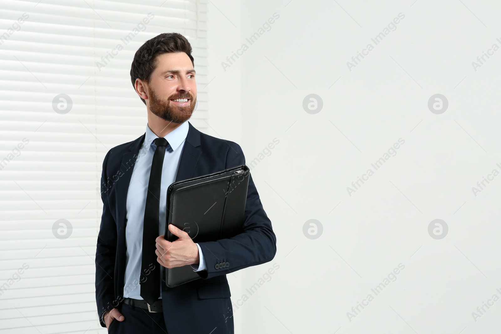 Photo of Handsome real estate agent with documents indoors, space for text