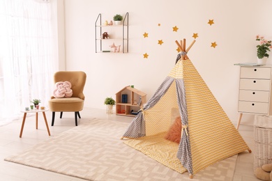 Photo of Cozy child's room interior with play tent and toys
