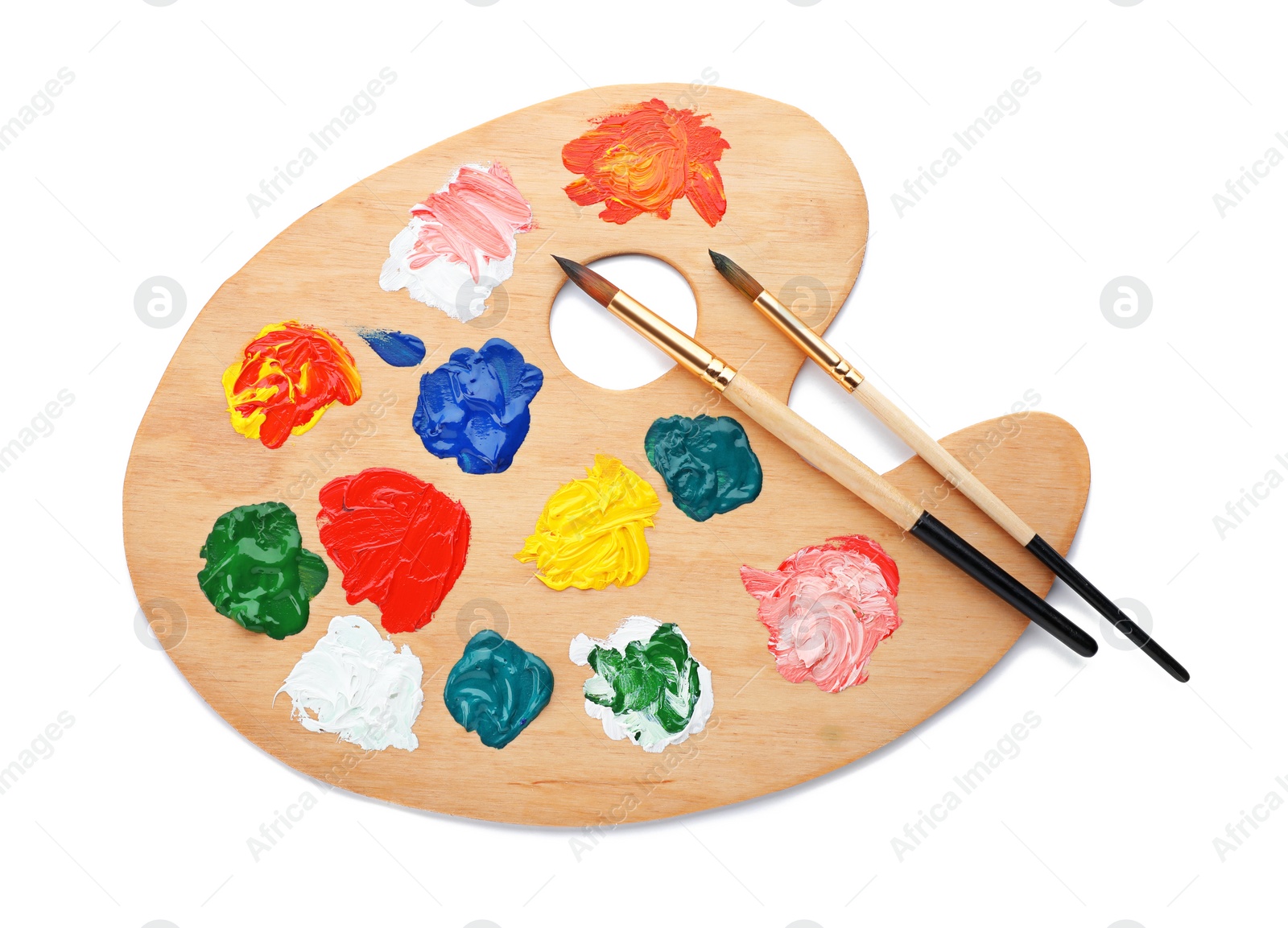 Photo of Wooden palette with paints and brushes on white background, top view