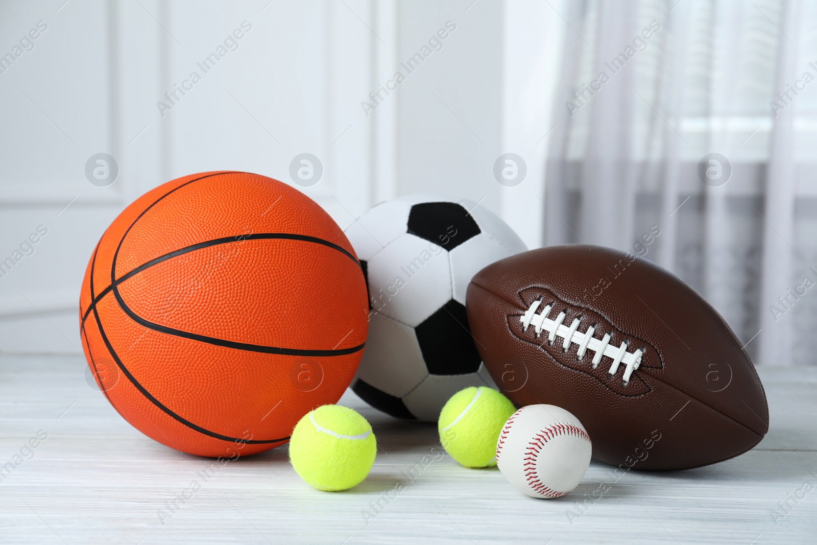 Photo of Set of different sport balls on white wooden table indoors