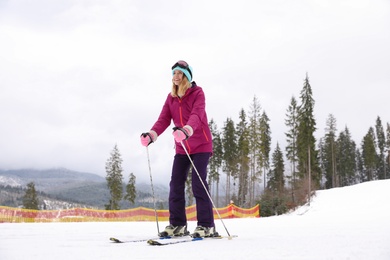 Female skier on slope at resort. Winter vacation