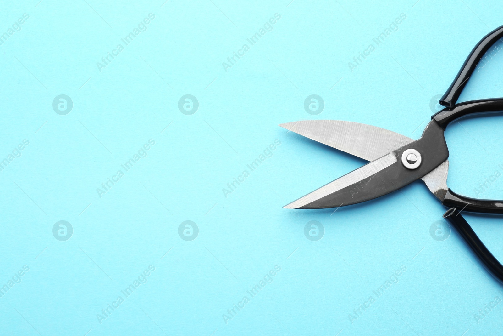 Photo of Pair of sharp scissors on color background, top view. Space for text