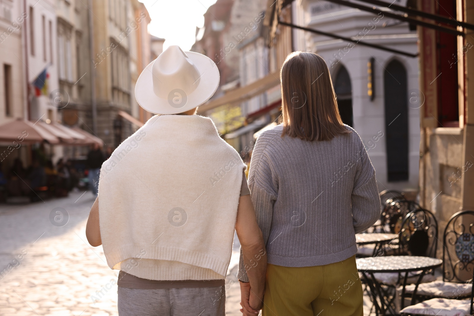 Photo of Affectionate senior couple walking outdoors, back view