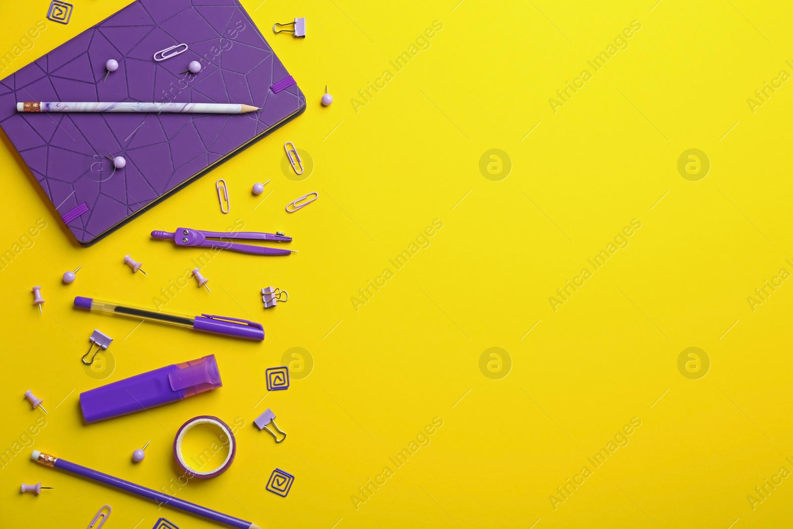 Photo of Purple school stationery on yellow background, flat lay. Space for text