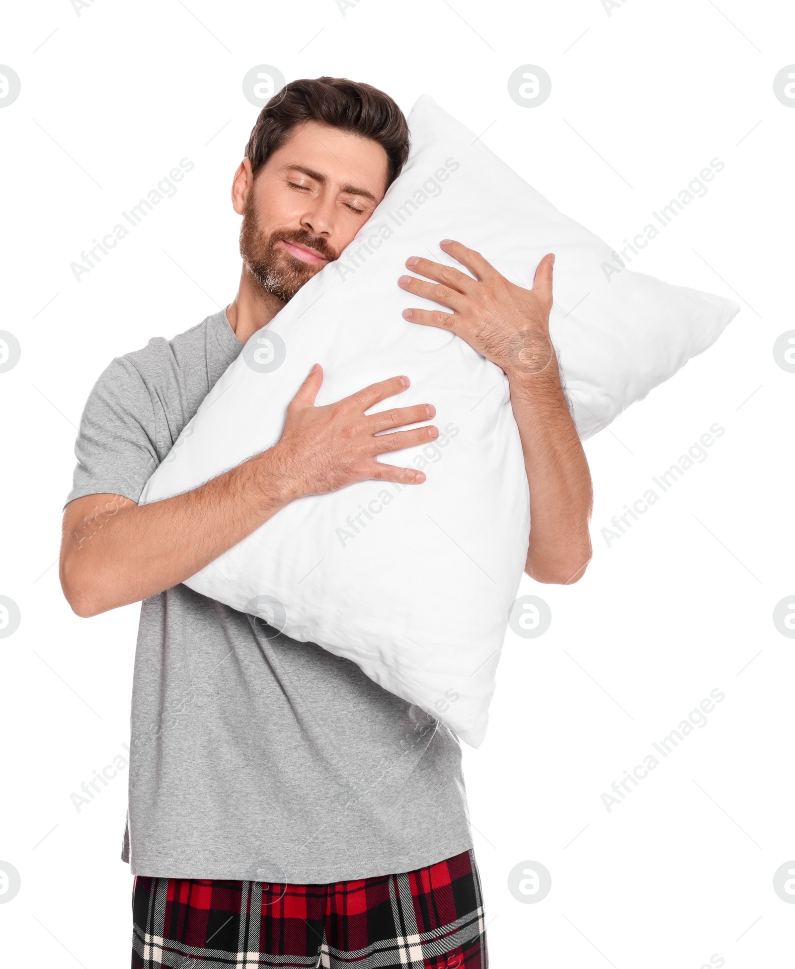 Photo of Sleepy handsome man hugging soft pillow on white background