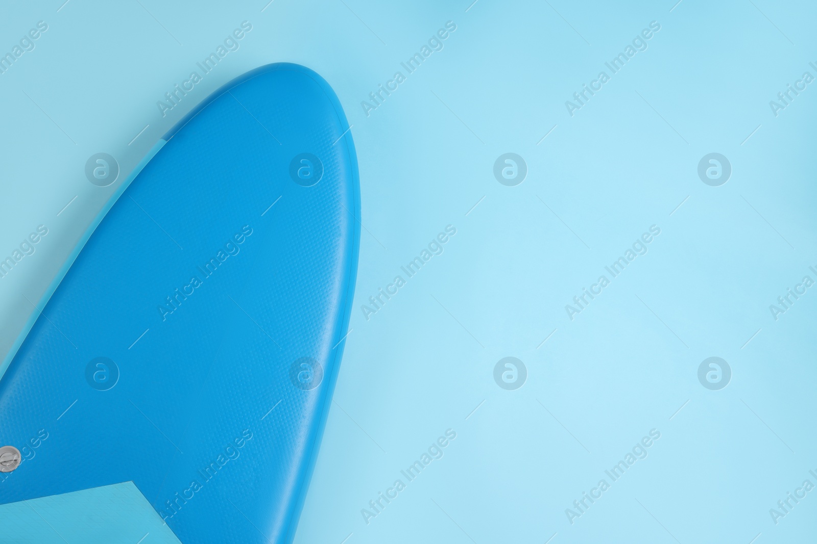 Photo of One SUP board on light blue background, top view with space for text. Water sport