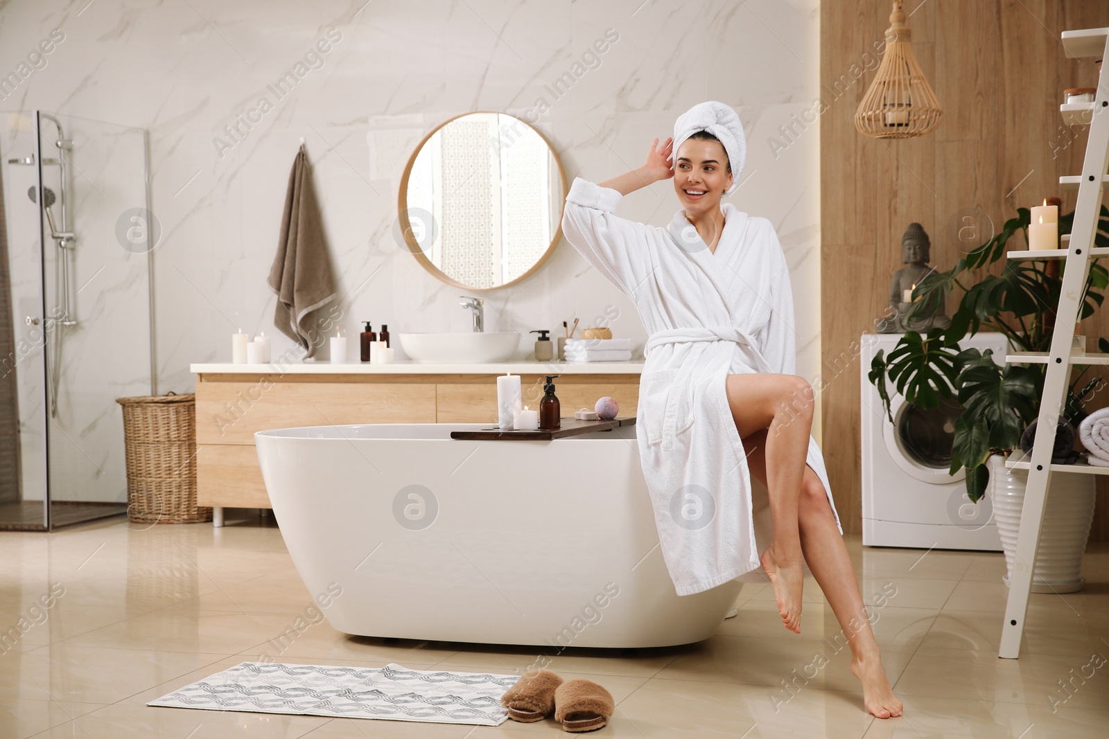 Photo of Beautiful young woman sitting on edge of tub in bathroom