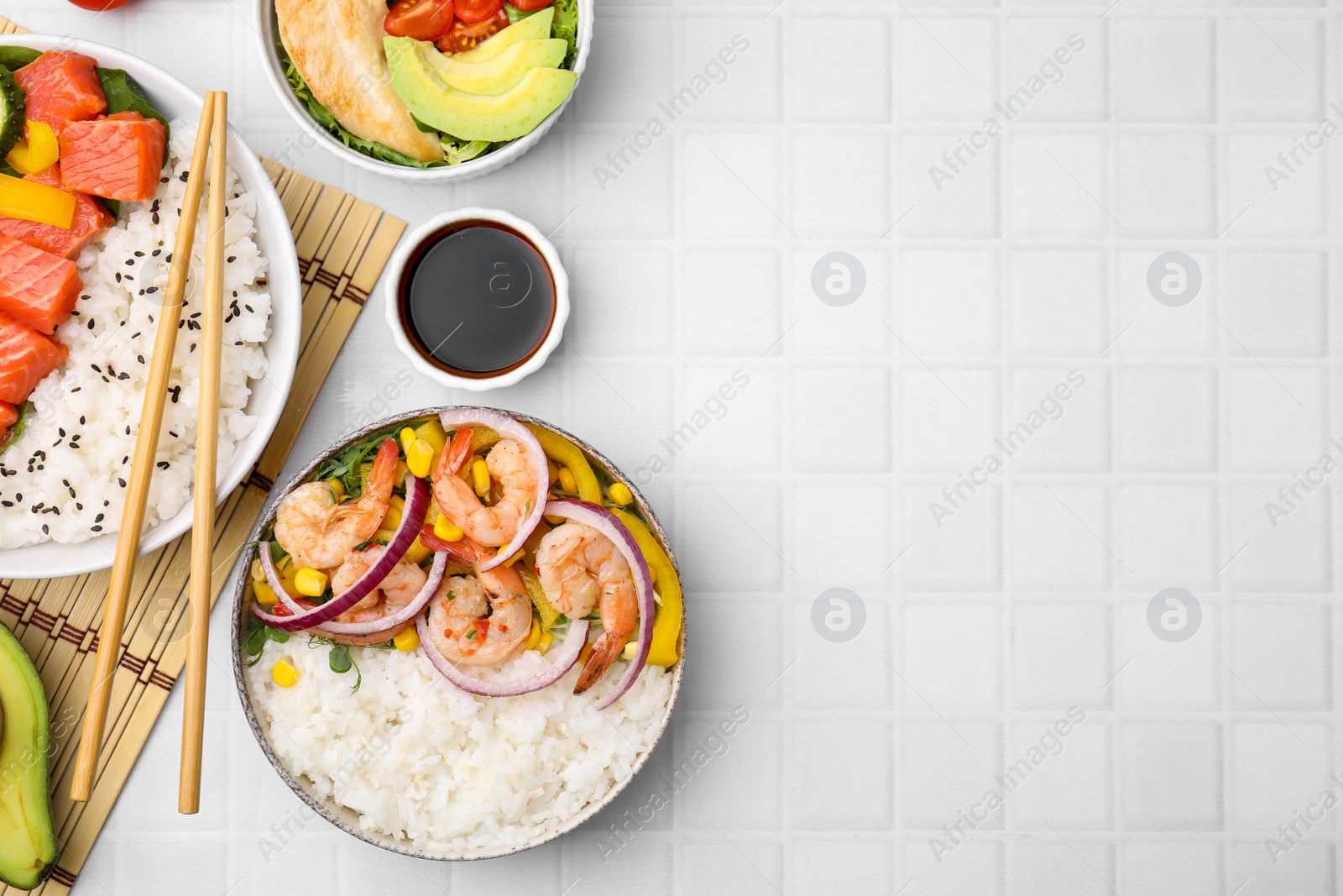 Photo of Set of delicious poke bowls with different ingredients on white table, flat lay. Space for text