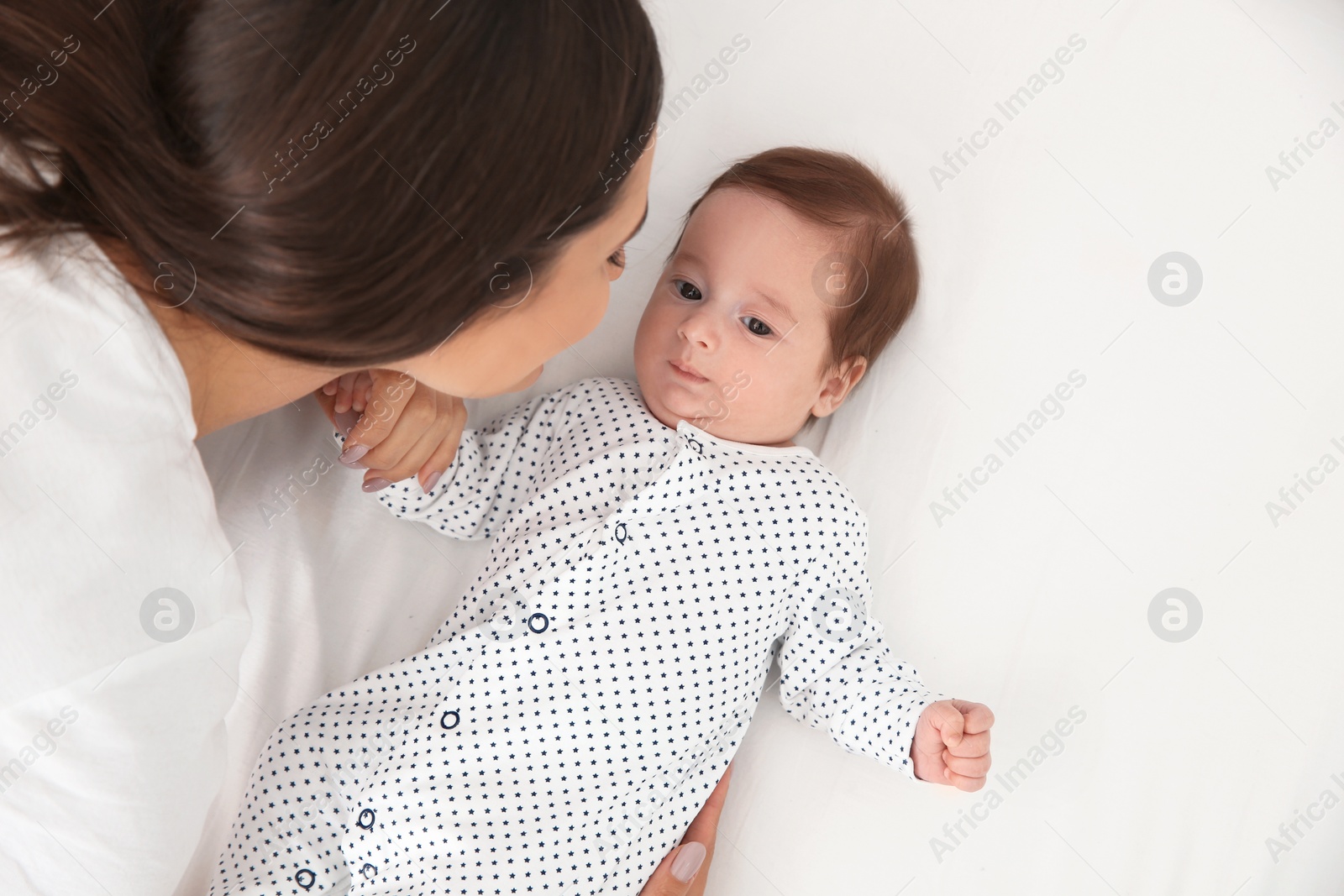 Photo of Happy woman with her baby on bed, above view