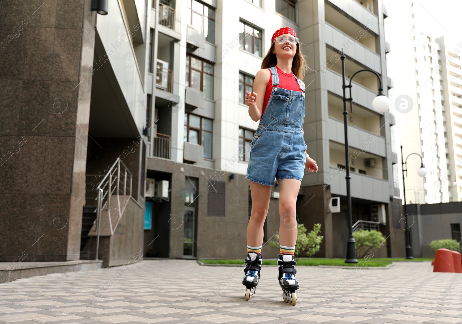 Photo of Beautiful young woman with roller skates having fun outdoors, space for text