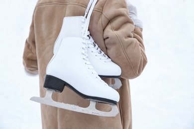 Woman with figure skates on white background, closeup