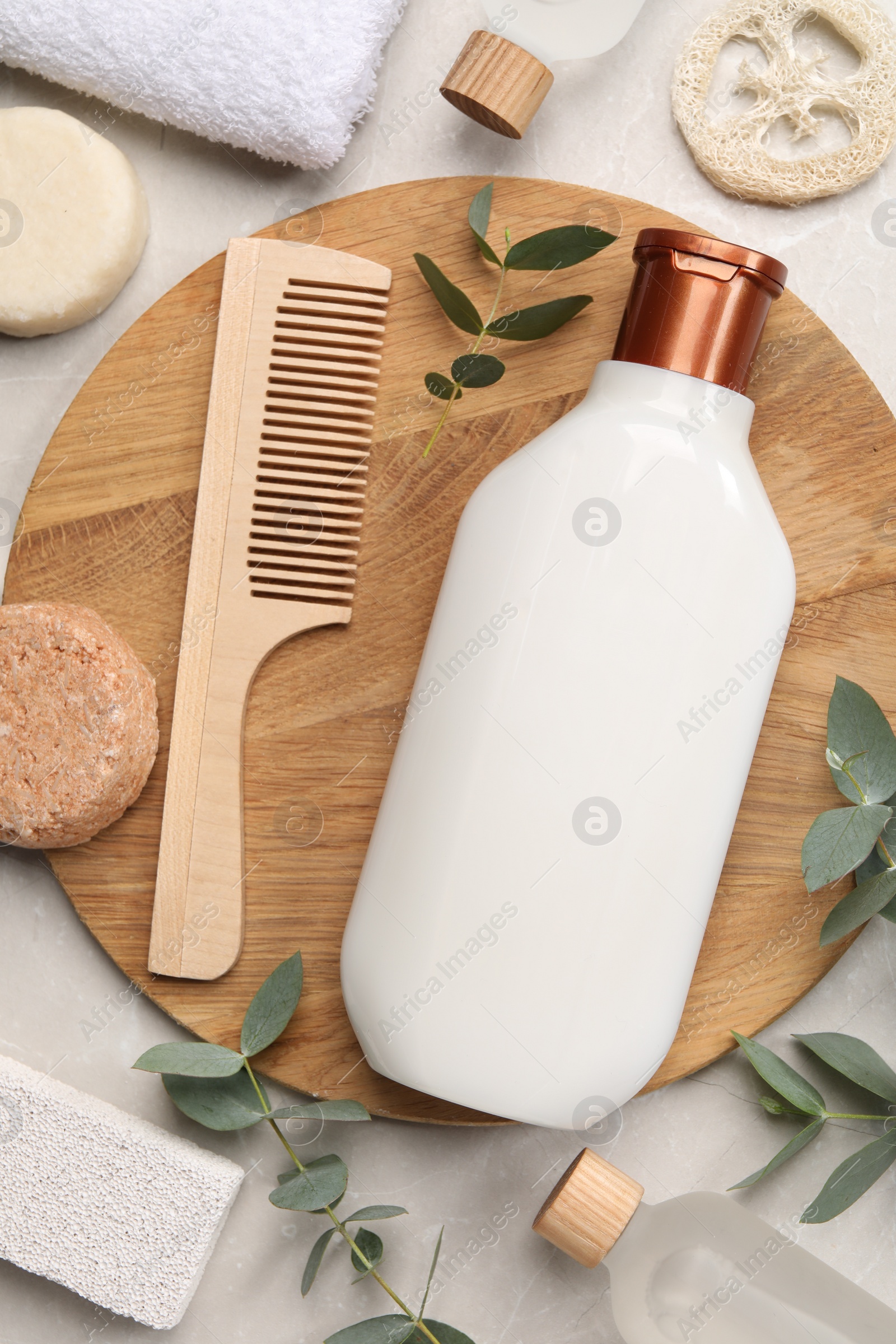 Photo of Flat lay composition with solid shampoo bar and bottle of cosmetic product on light grey table