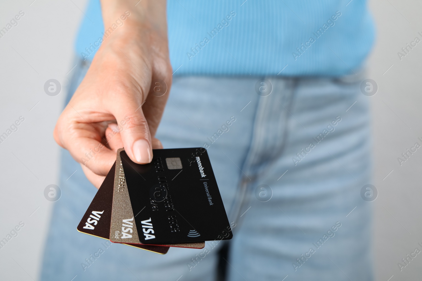 Photo of MYKOLAIV, UKRAINE - FEBRUARY 22, 2022: Woman holding Visa credit cards on white background, closeup. Space for text