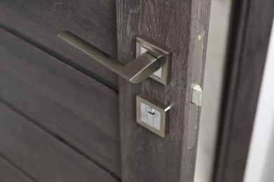 Photo of Open wooden door with metal handle, closeup