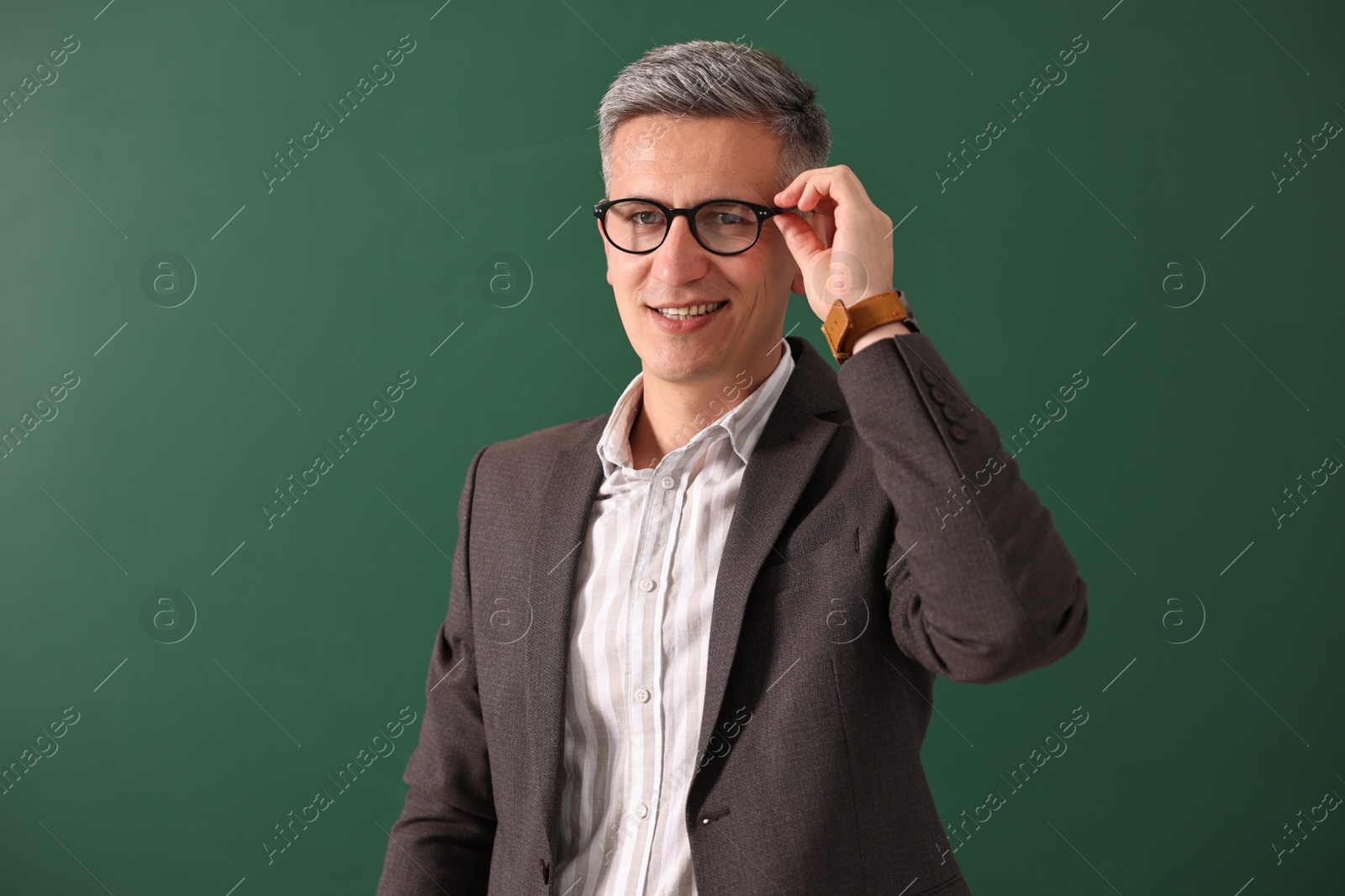 Photo of Portrait of teacher in glasses near chalkboard