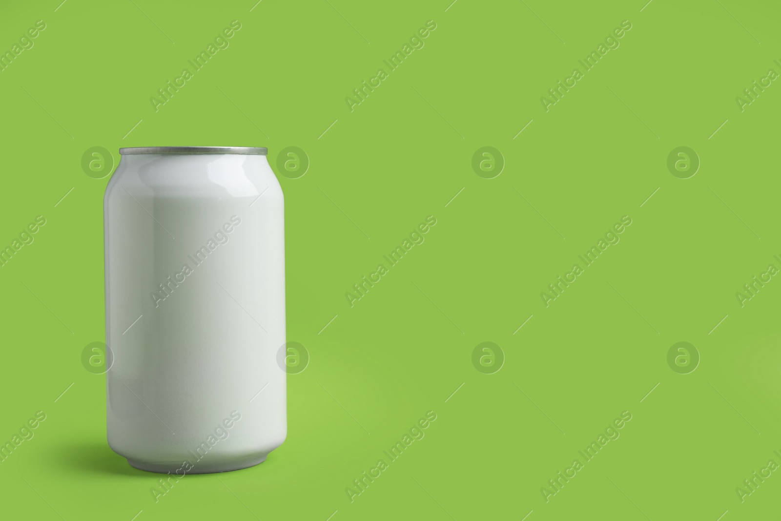 Photo of White can of energy drink on green background. Space for text
