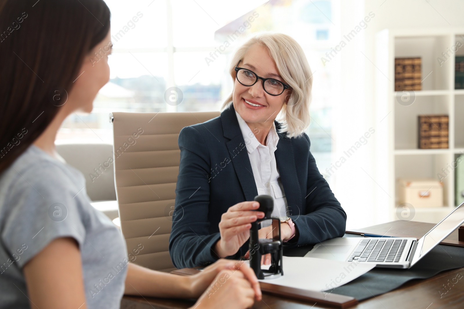 Photo of Female notary working with client in office