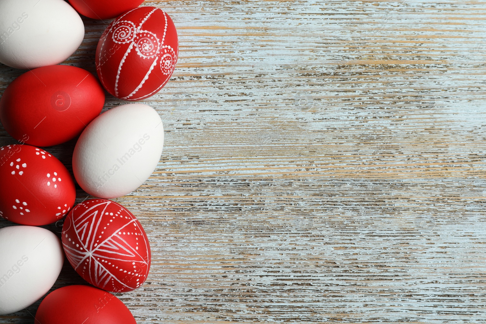 Photo of Flat lay composition of painted red Easter eggs on wooden table, space for text