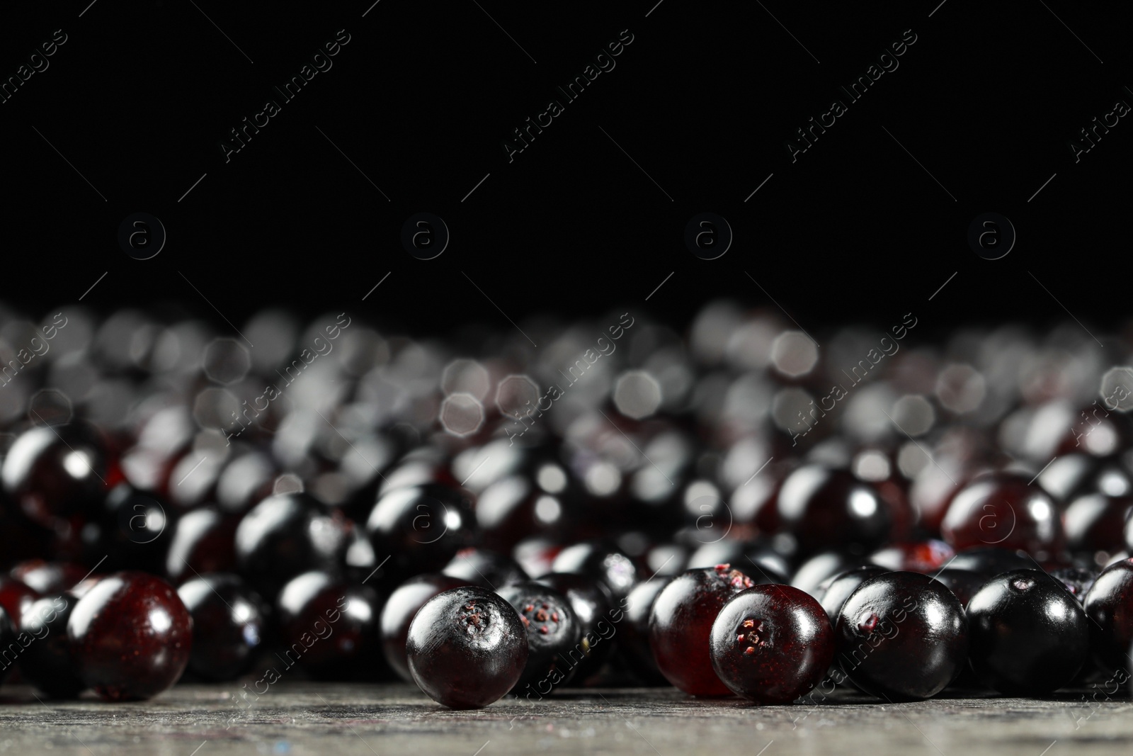 Photo of Many elderberries (Sambucus) on grey table, closeup. Space for text