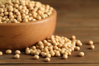 Photo of Bowl with soy on wooden table, closeup. Space for text