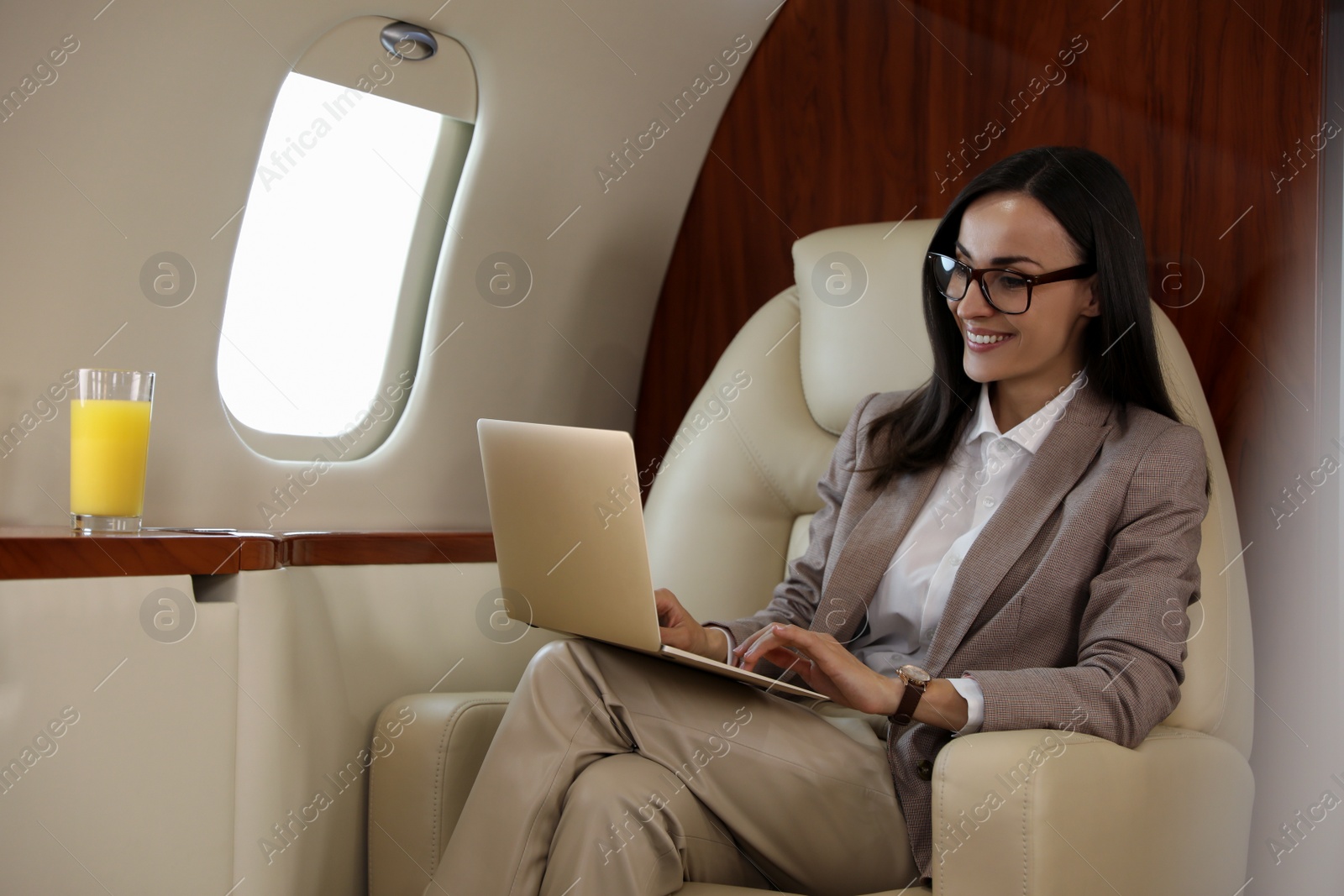 Photo of Businesswoman working on laptop in airplane during flight