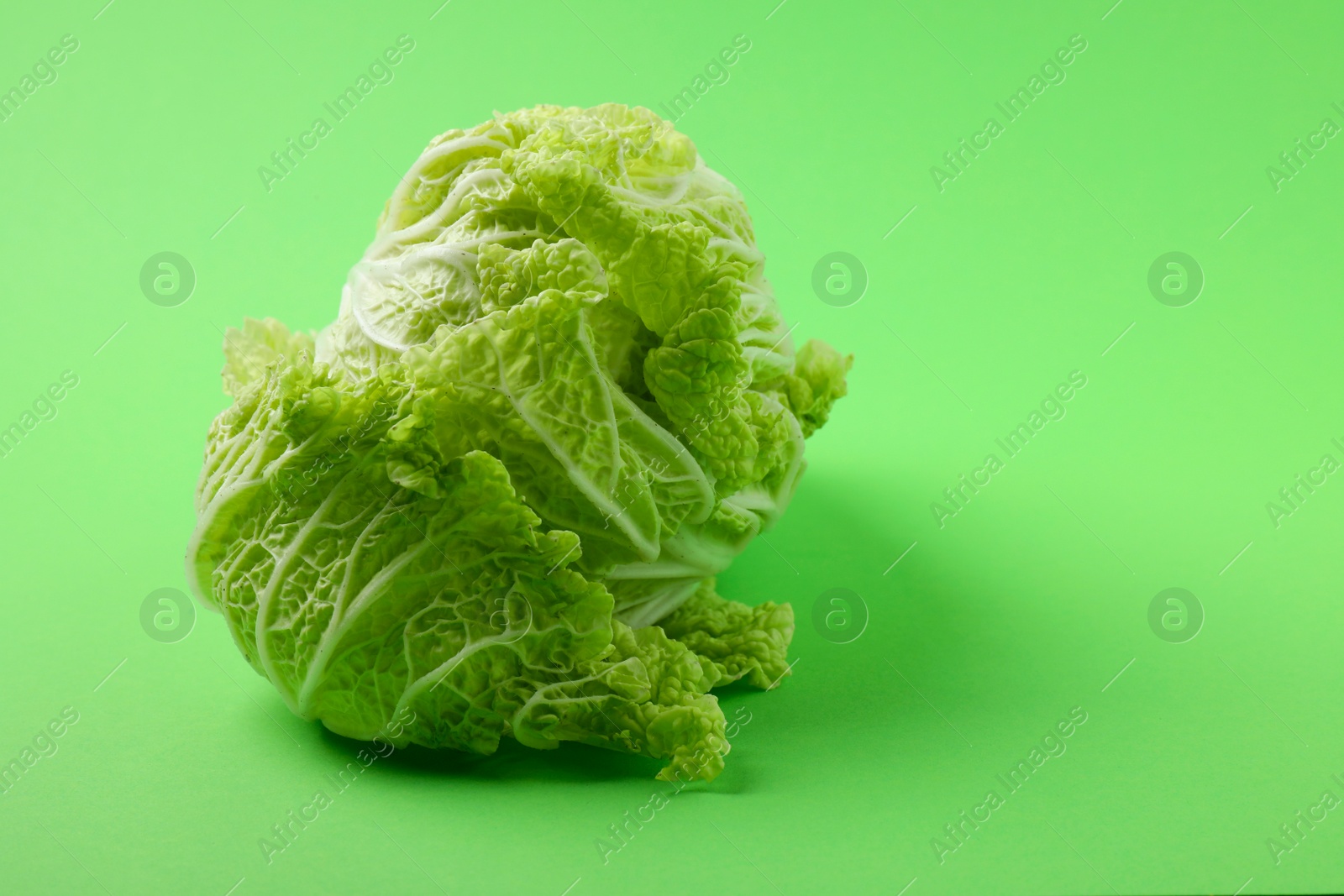 Photo of Fresh ripe Chinese cabbage on light green background, space for text