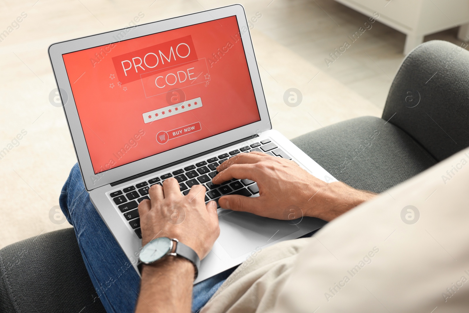 Photo of Man holding laptop with activated promo code on sofa, closeup