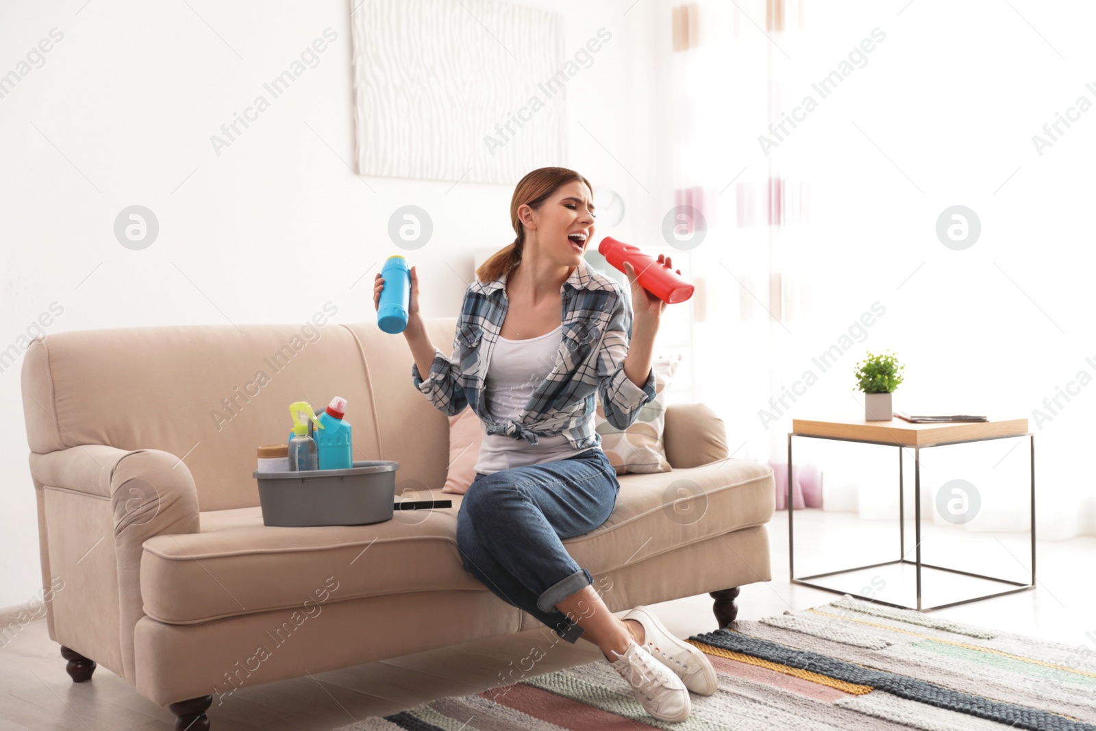 Photo of Happy woman having fun while cleaning room